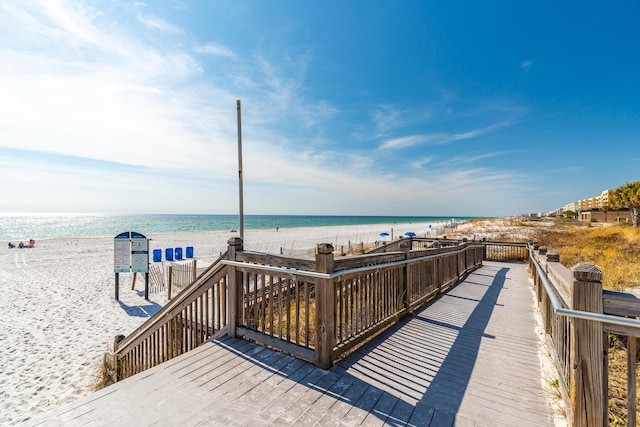 wooden deck with a water view and a view of the beach