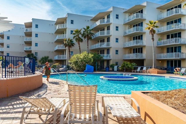 view of pool with a hot tub