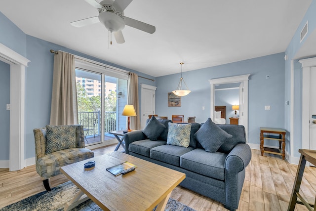 living room with ceiling fan and light wood-type flooring