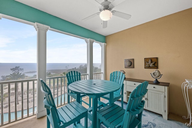 balcony with ceiling fan and a water view