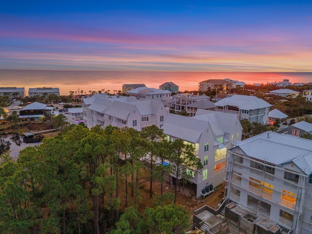 aerial view at dusk featuring a water view