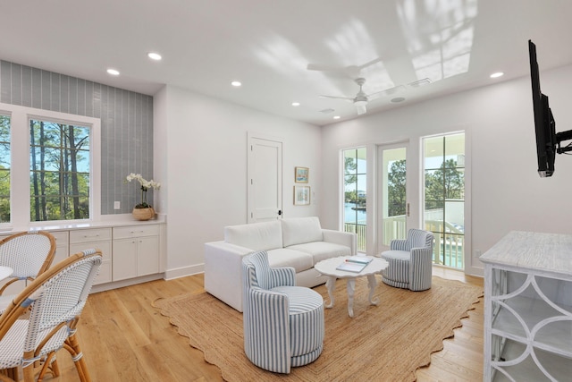 living room with light hardwood / wood-style flooring and ceiling fan