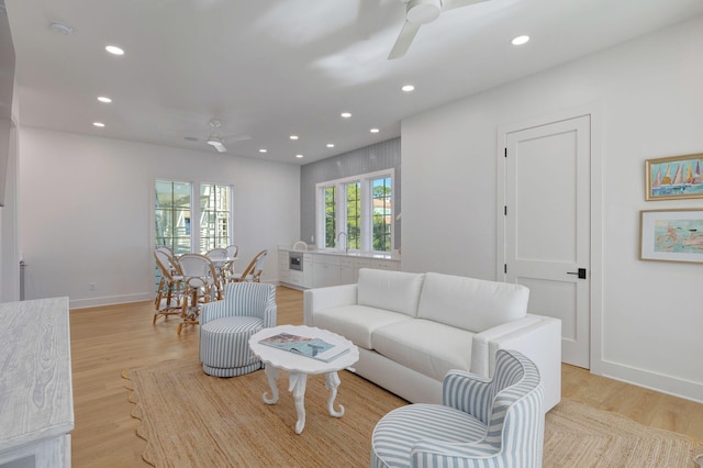 living room with light hardwood / wood-style flooring and ceiling fan