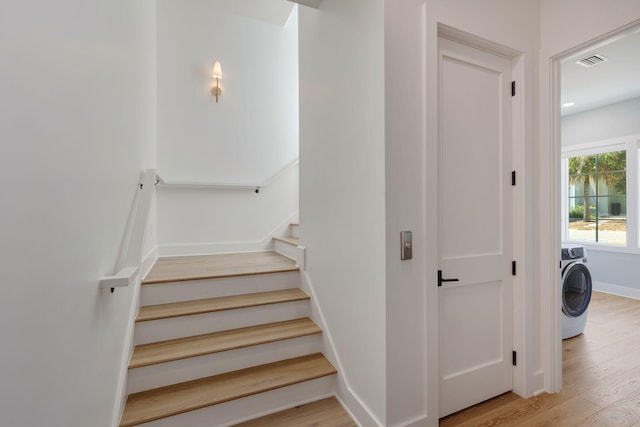 stairway with washer / clothes dryer and hardwood / wood-style flooring