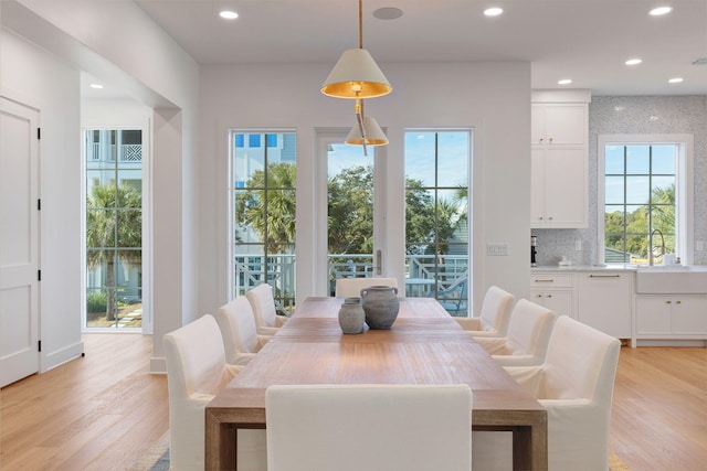 dining area with sink and light wood-type flooring