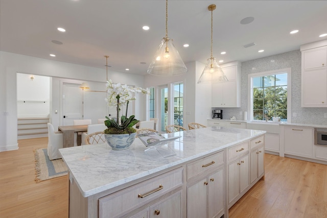 kitchen with a center island, backsplash, and light hardwood / wood-style floors