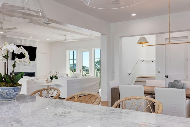 dining space with ceiling fan and a fireplace