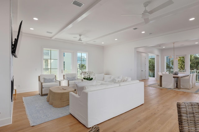 living room featuring ceiling fan, beam ceiling, light hardwood / wood-style floors, and a wealth of natural light