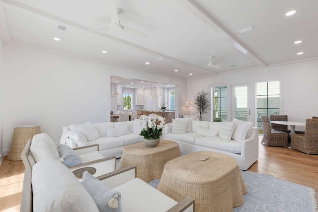 living room with ceiling fan, beam ceiling, and light hardwood / wood-style flooring