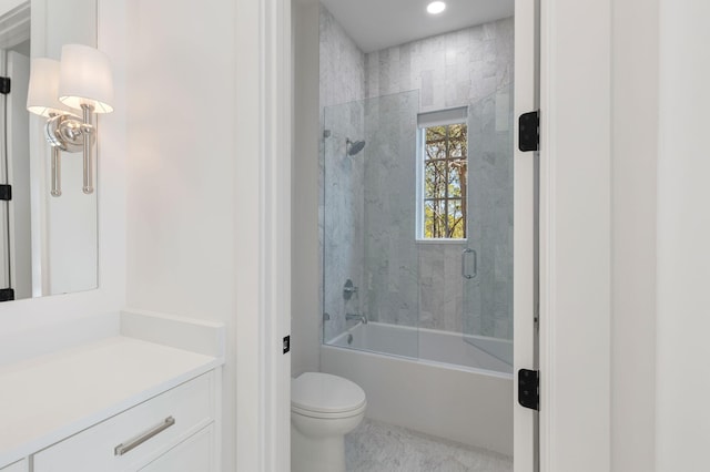 full bathroom with enclosed tub / shower combo, vanity, and toilet