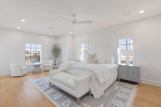 bedroom featuring multiple windows, ceiling fan, and light wood-type flooring