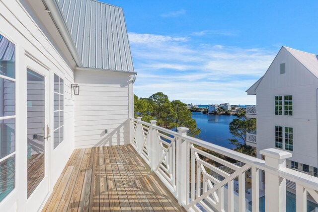 wooden terrace featuring a water view and french doors