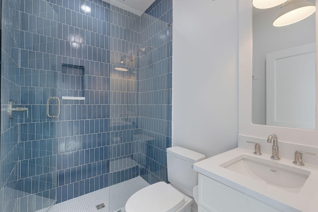 bathroom featuring vanity, a shower with shower door, and toilet