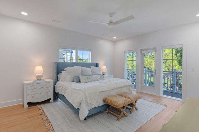 bedroom featuring multiple windows, access to outside, and light wood-type flooring