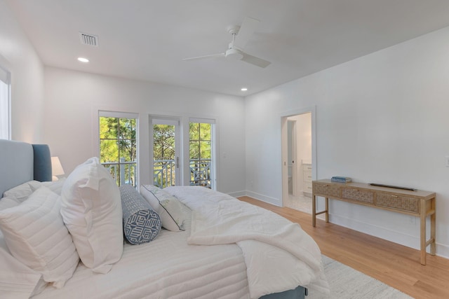 bedroom featuring ceiling fan, ensuite bath, and light wood-type flooring