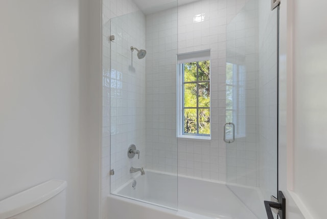 bathroom with combined bath / shower with glass door and toilet