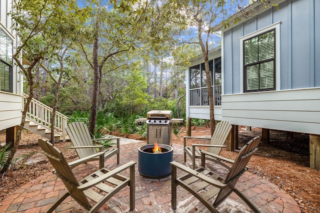 view of patio featuring a fire pit and a sunroom