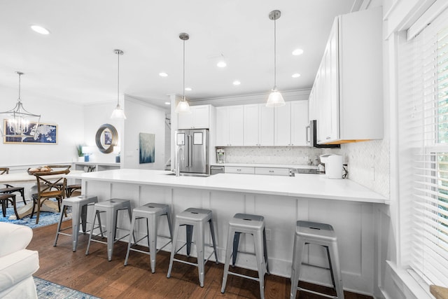 kitchen with a kitchen bar, white cabinetry, dark hardwood / wood-style floors, hanging light fixtures, and high end refrigerator