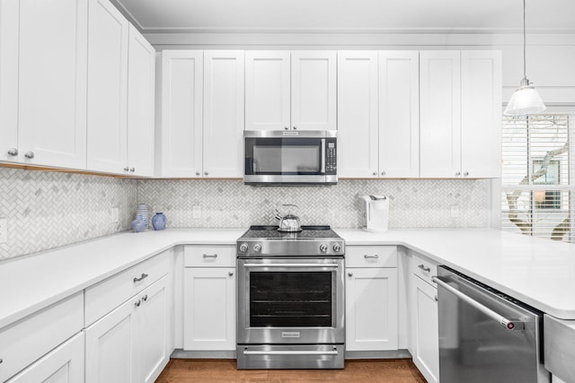 kitchen with white cabinetry, backsplash, stainless steel appliances, and pendant lighting