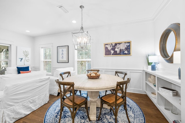 dining room featuring a chandelier, crown molding, and dark hardwood / wood-style floors