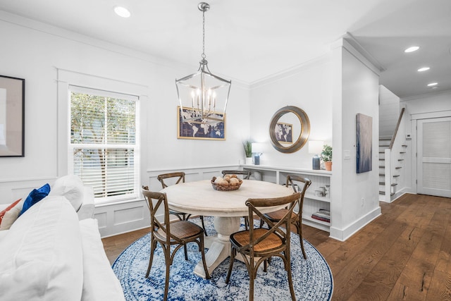 dining room featuring ornamental molding, dark wood-type flooring, and an inviting chandelier