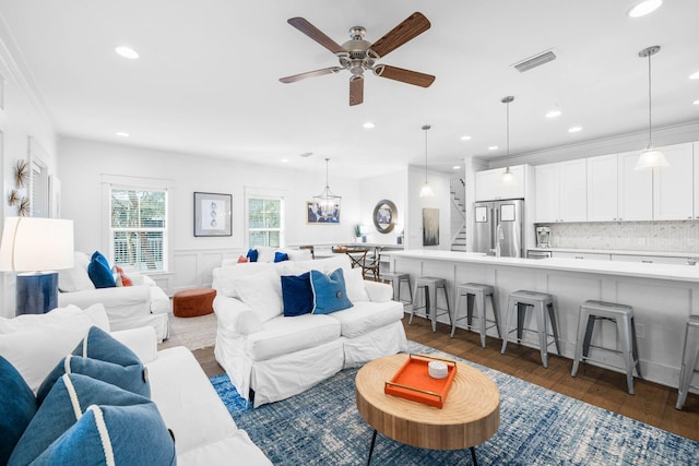 living room with crown molding, dark hardwood / wood-style flooring, and ceiling fan