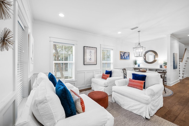 living room with hardwood / wood-style floors, a healthy amount of sunlight, and ornamental molding