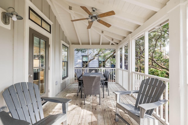 sunroom / solarium featuring ceiling fan, vaulted ceiling with beams, and a healthy amount of sunlight