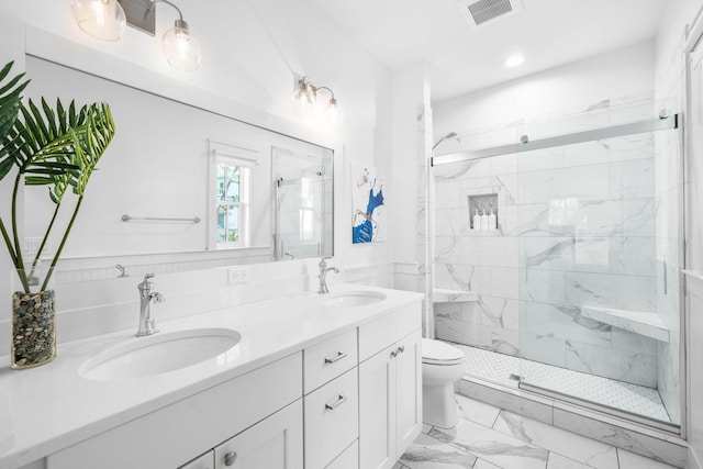 bathroom featuring vanity, a shower with shower door, and toilet