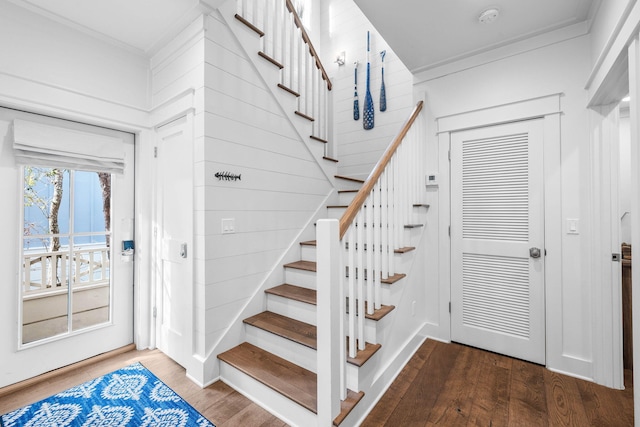 staircase with crown molding and wood-type flooring