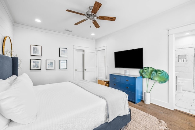 bedroom with connected bathroom, crown molding, wood-type flooring, and ceiling fan