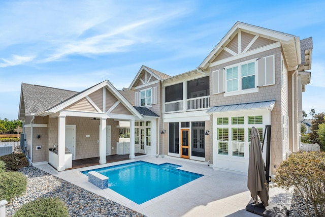 back of house featuring a patio, a sunroom, a ceiling fan, a fenced in pool, and a standing seam roof