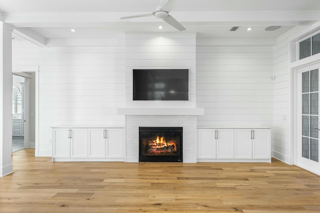 unfurnished living room featuring beam ceiling, a fireplace, visible vents, light wood-style flooring, and ceiling fan