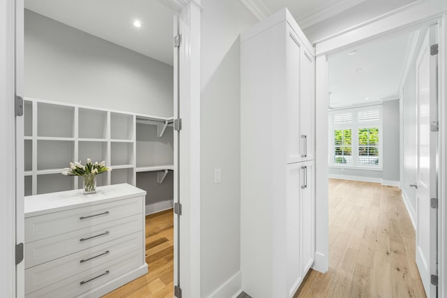 hallway featuring ornamental molding and light wood-type flooring