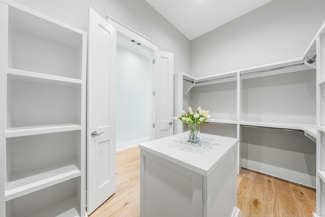 walk in closet with lofted ceiling and light wood-type flooring