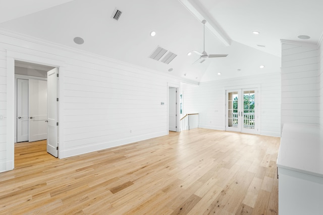 unfurnished living room with french doors, ceiling fan, lofted ceiling with beams, and light wood-type flooring