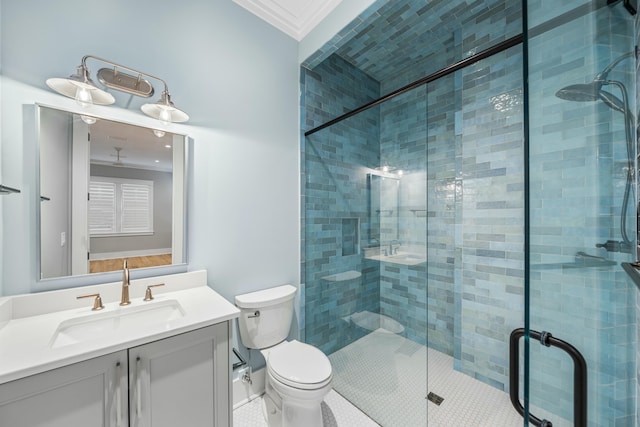 bathroom featuring a shower with door, crown molding, vanity, and toilet