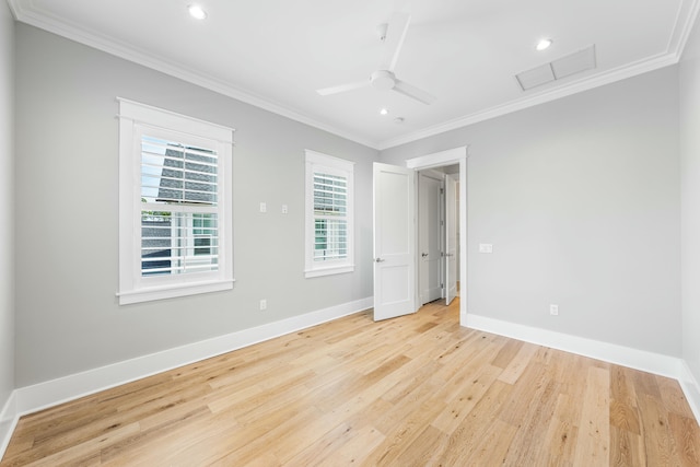 unfurnished room with ornamental molding, visible vents, light wood-style flooring, and baseboards