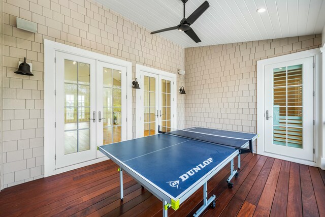 playroom featuring tile walls, dark hardwood / wood-style floors, french doors, and ceiling fan