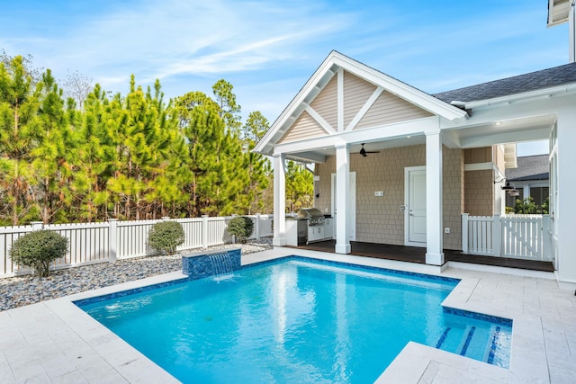 view of pool featuring an outdoor kitchen, a fenced backyard, a ceiling fan, a fenced in pool, and a patio area