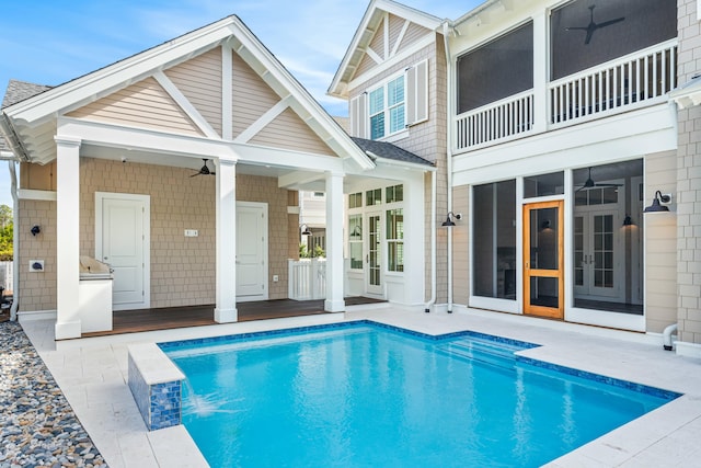 view of pool featuring pool water feature, ceiling fan, a patio area, and french doors