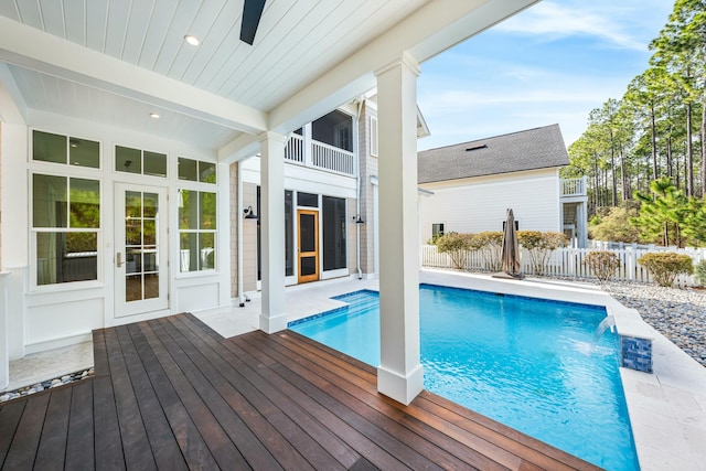 view of swimming pool featuring a wooden deck, pool water feature, and ceiling fan