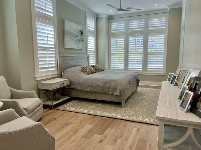 bedroom featuring multiple windows, crown molding, and wood finished floors