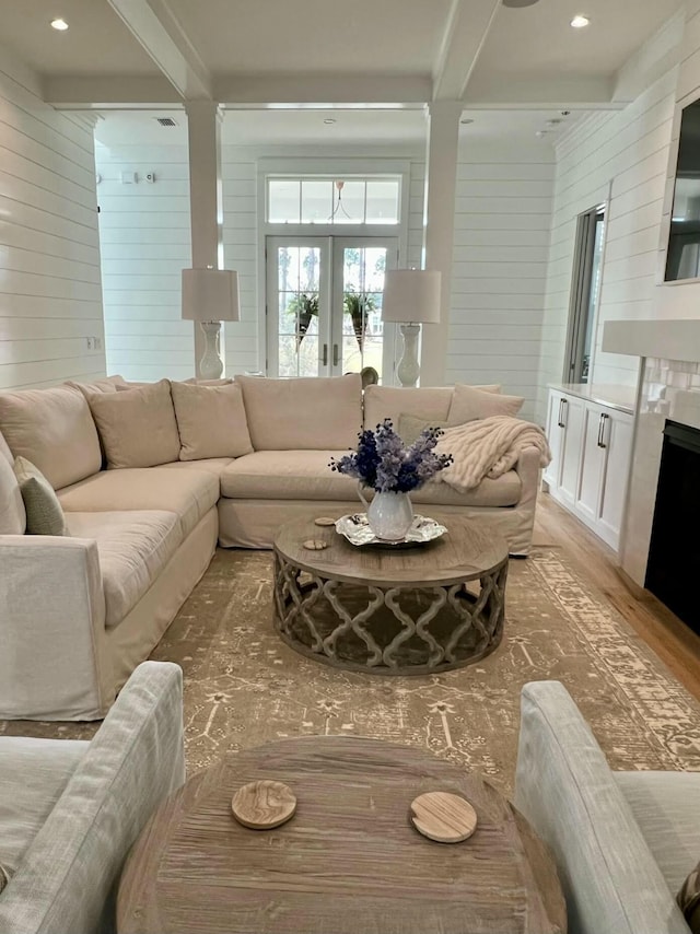 living area featuring french doors, recessed lighting, wooden walls, wood finished floors, and beamed ceiling