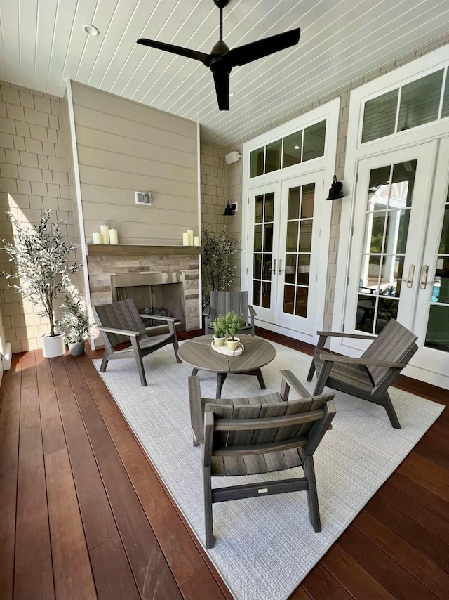 deck with french doors, a fireplace, and ceiling fan