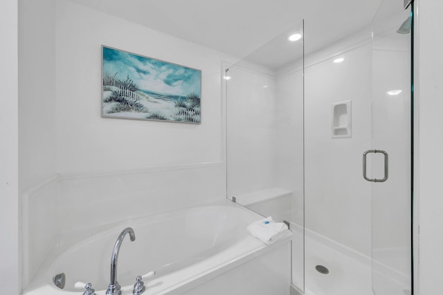 bathroom featuring shower with separate bathtub