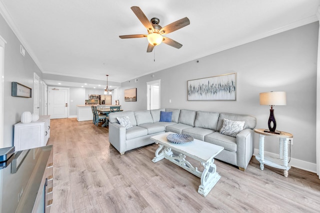 living room featuring crown molding, ceiling fan, and light hardwood / wood-style floors