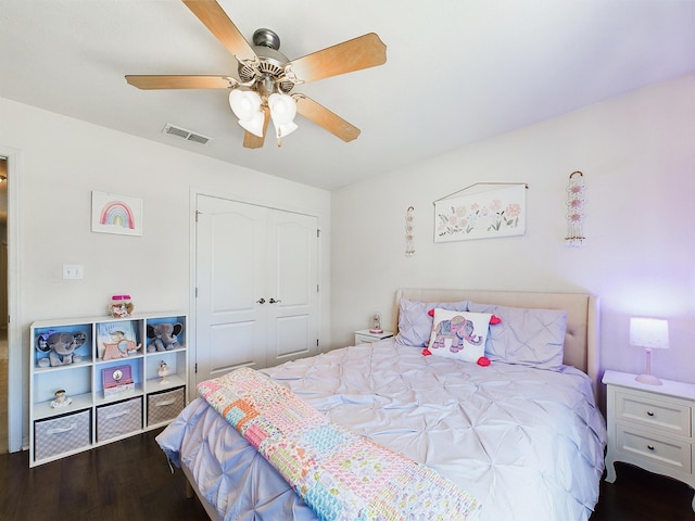 bedroom with ceiling fan, a closet, visible vents, and wood finished floors