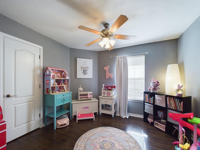 game room with a textured ceiling, ceiling fan, wood finished floors, and baseboards