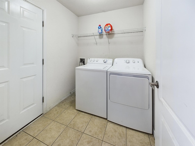 laundry area with washing machine and dryer, laundry area, and light tile patterned floors